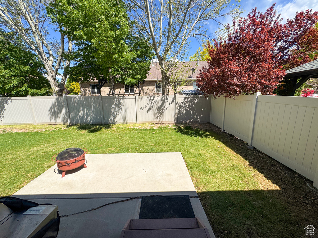 View of yard with an outdoor fire pit and a fenced backyard