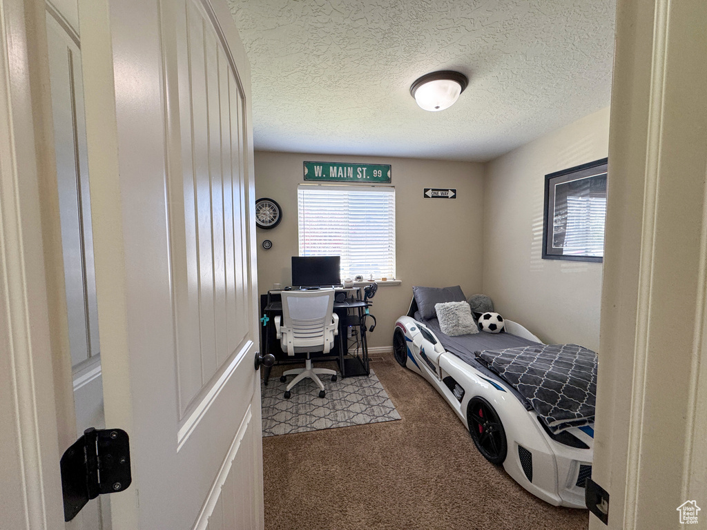 Carpeted bedroom featuring a textured ceiling