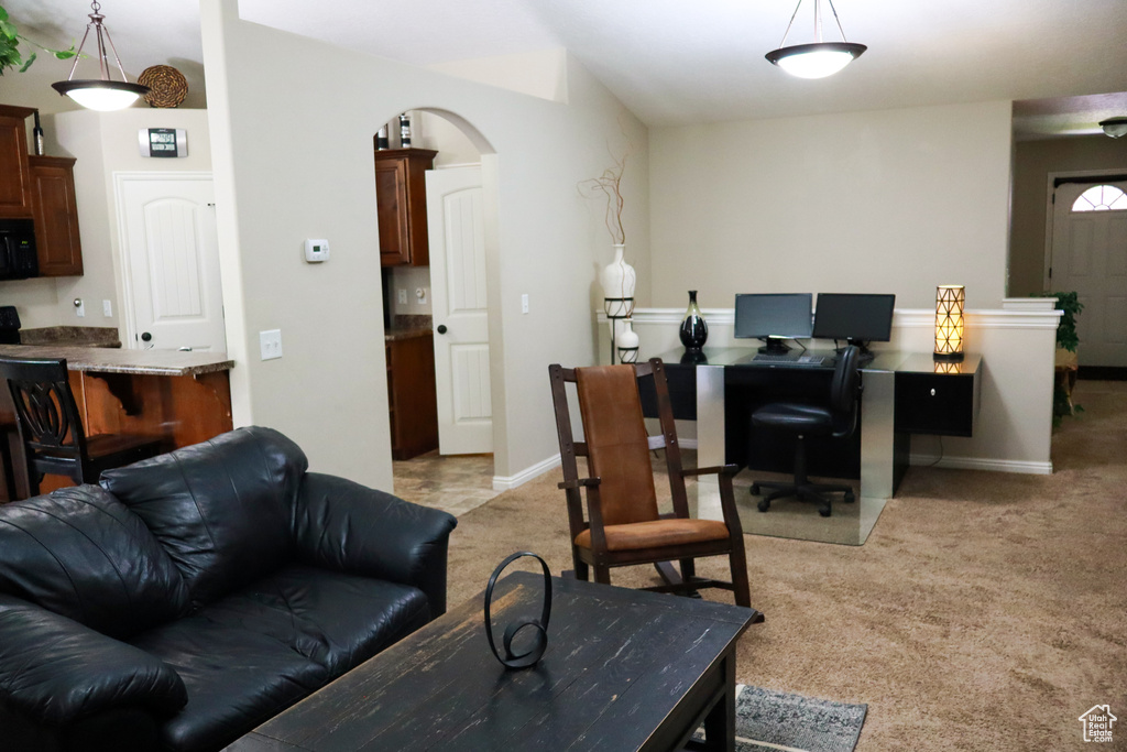 Office space featuring light colored carpet, baseboards, and arched walkways
