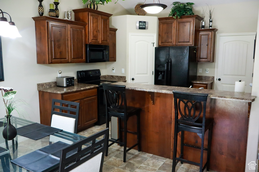 Kitchen with a kitchen breakfast bar and black appliances