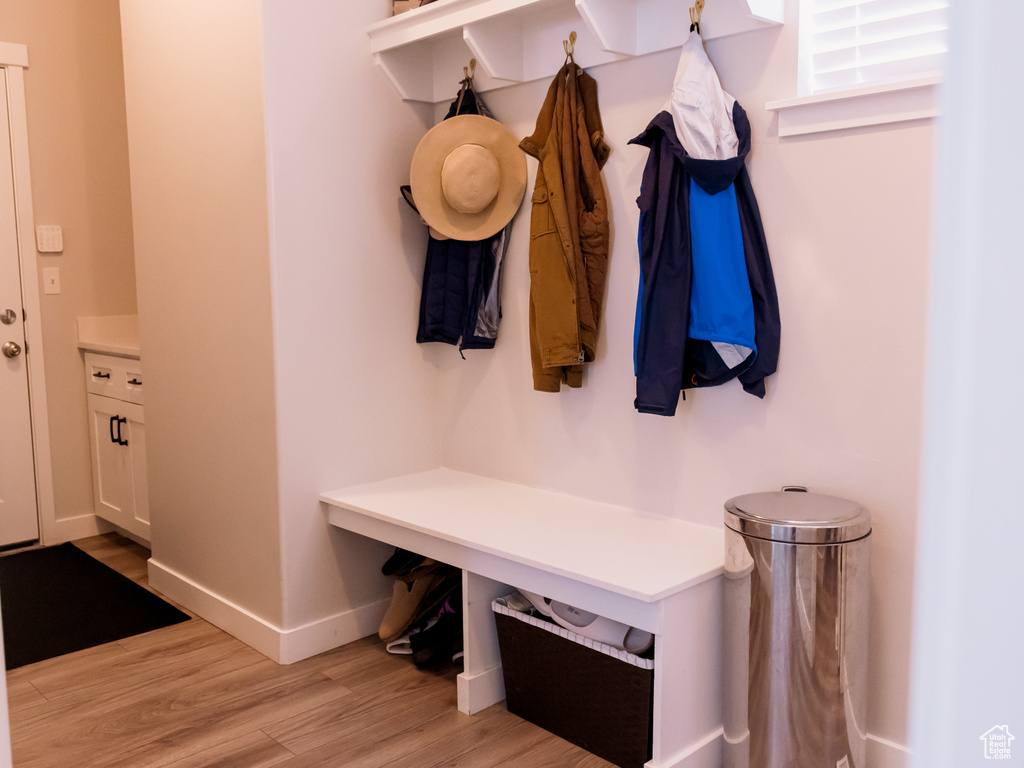 Mudroom with light wood finished floors and baseboards
