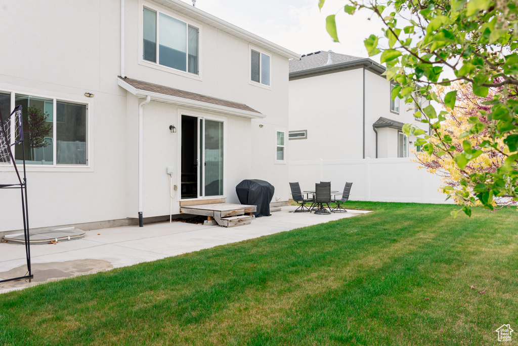 Rear view of property featuring stucco siding and a patio area