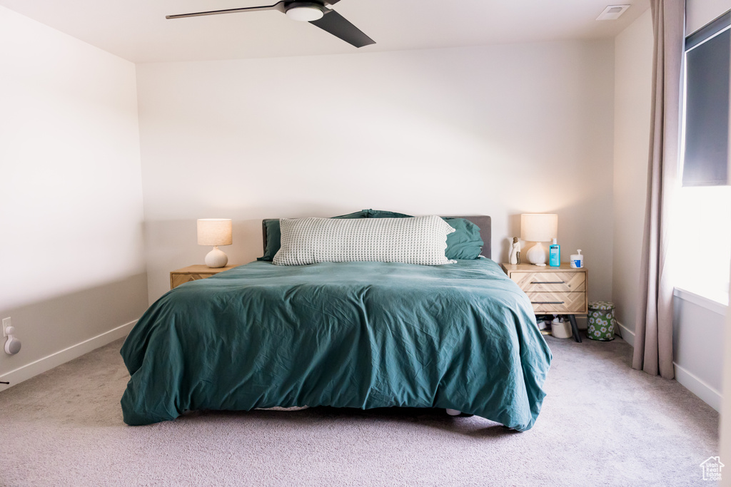 Carpeted bedroom with a ceiling fan and baseboards