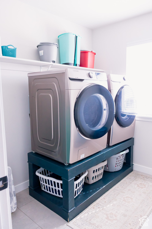 Washroom featuring washer and dryer, baseboards, and tile patterned floors
