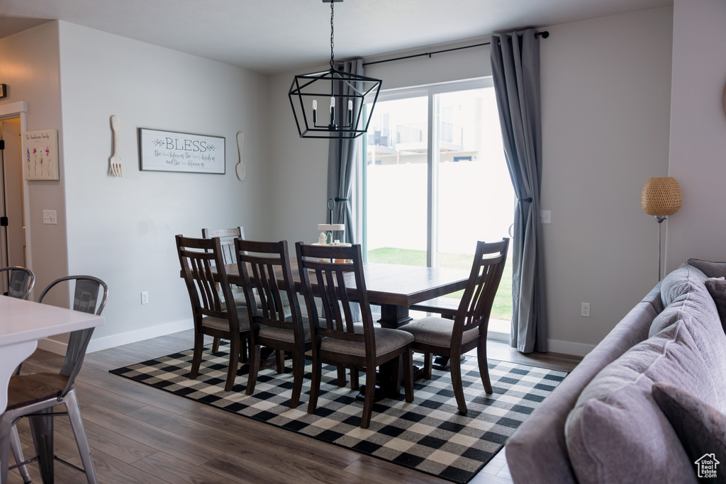 Dining space featuring a chandelier, dark wood-type flooring, and baseboards