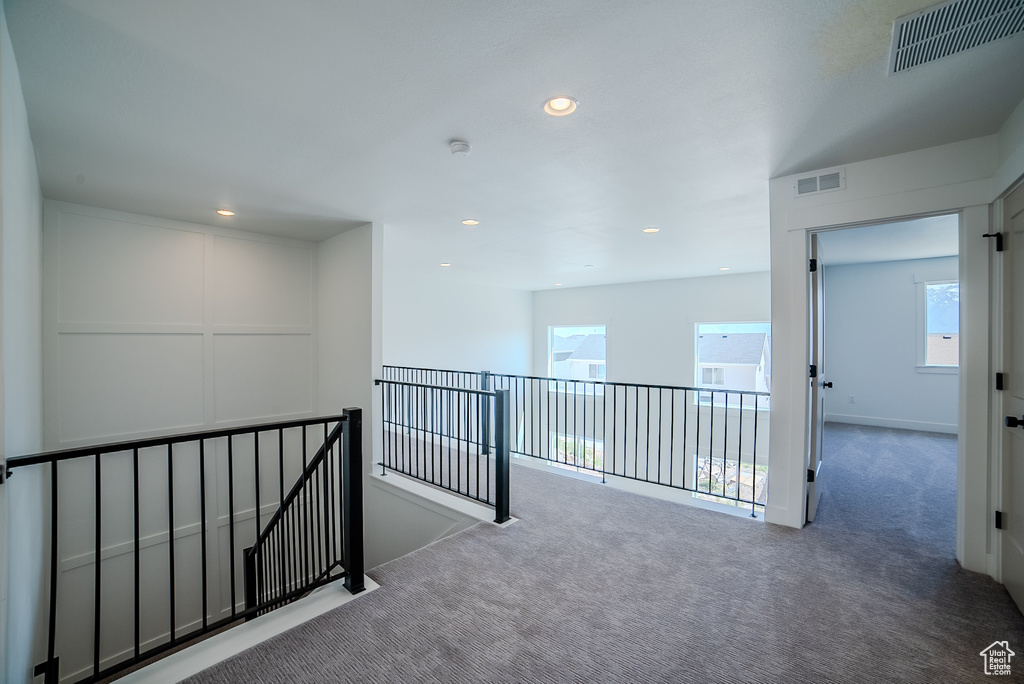 Hall with an upstairs landing, carpet floors, healthy amount of natural light, and recessed lighting