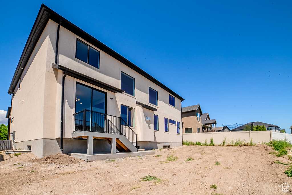 Back of house with fence and stucco siding