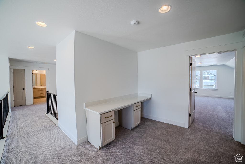 Unfurnished office with light carpet, recessed lighting, baseboards, and built in study area
