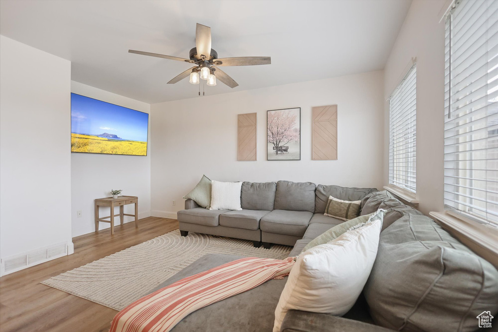 Living area featuring ceiling fan, wood finished floors, and baseboards