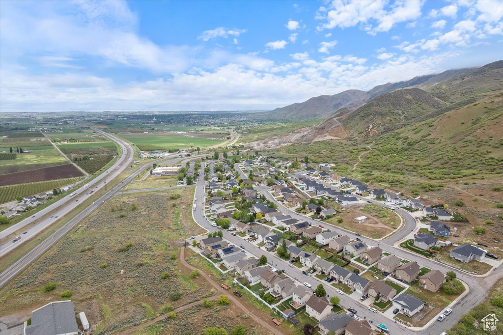 Aerial view of property and surrounding area featuring mountains and nearby suburban area