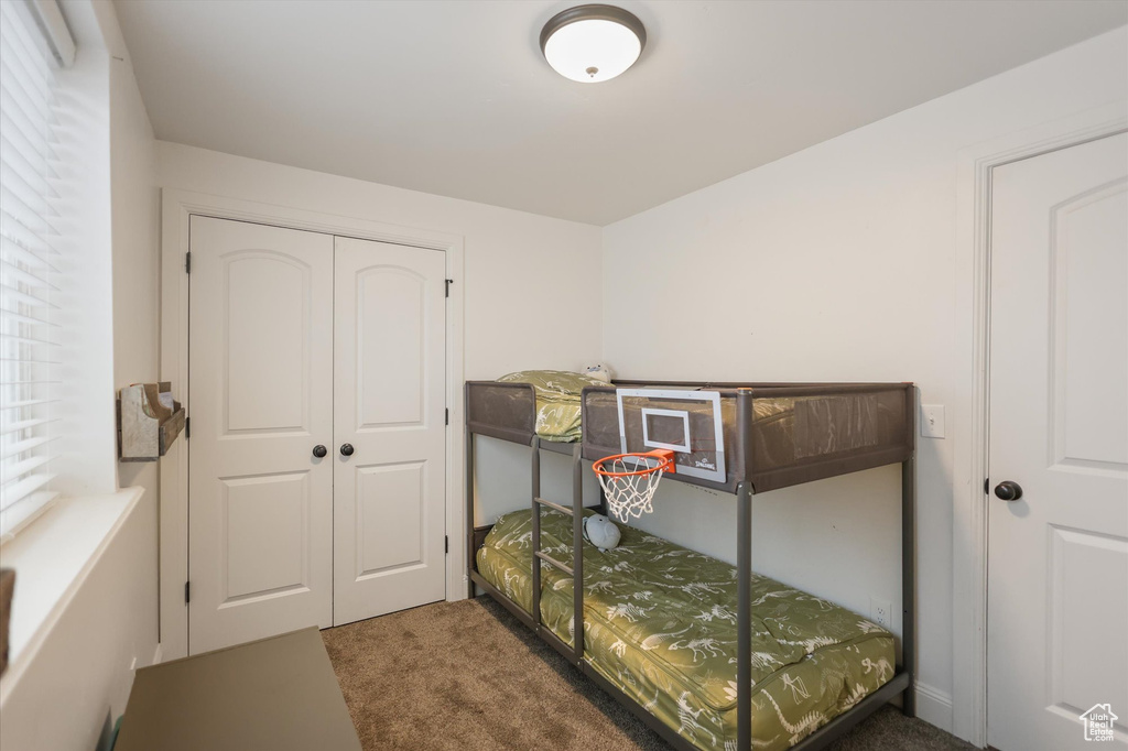 Carpeted bedroom featuring a closet
