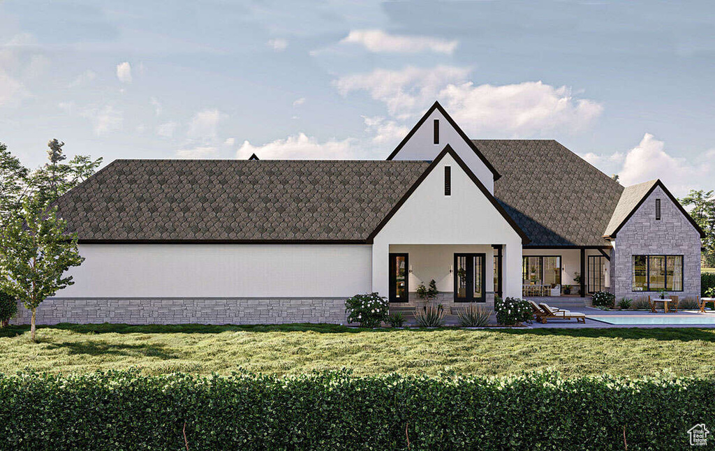 View of front facade featuring a patio area, a front lawn, and stone siding