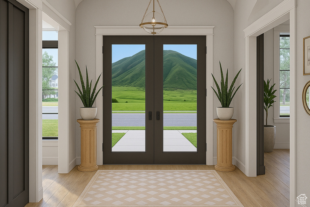 Foyer entrance featuring light wood-type flooring, french doors, baseboards, and a mountain view