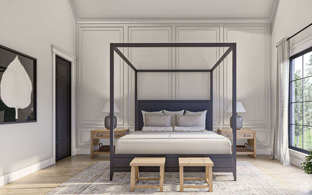 Bedroom with crown molding, baseboards, light wood-style flooring, and a decorative wall