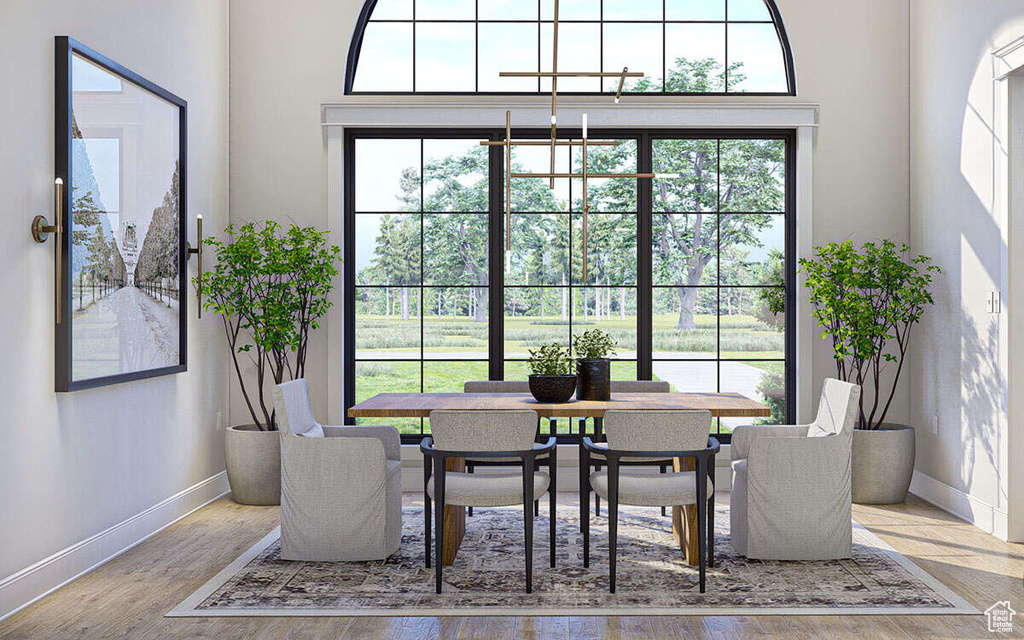 Dining room featuring baseboards, wood finished floors, and a chandelier