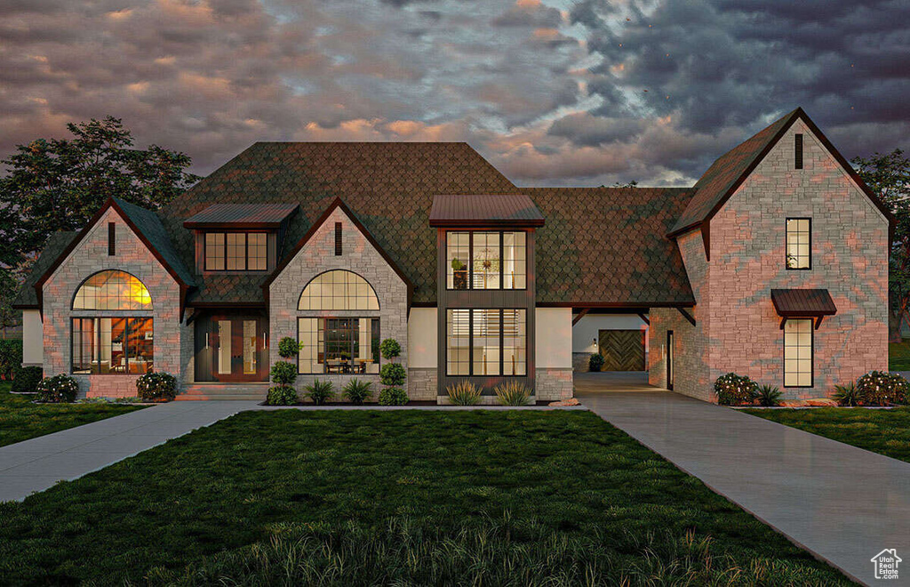 View of front of house with concrete driveway, a front yard, and stone siding
