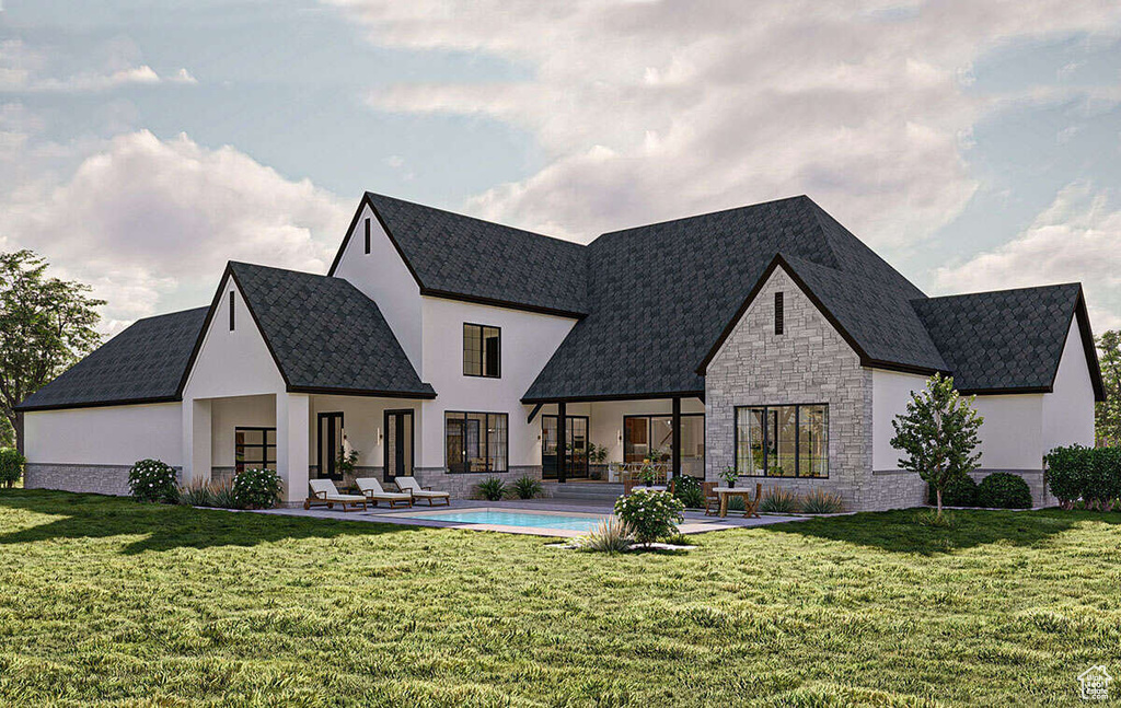 Back of property featuring a lawn, a patio area, an outdoor pool, and stone siding