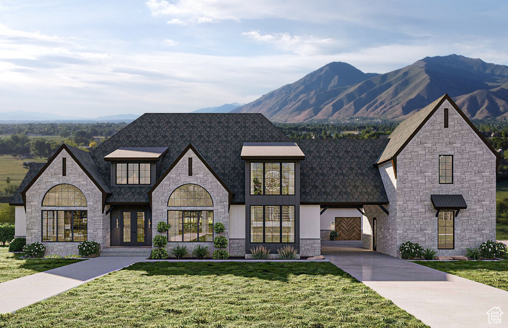 French provincial home featuring a mountain view, a front yard, and stone siding