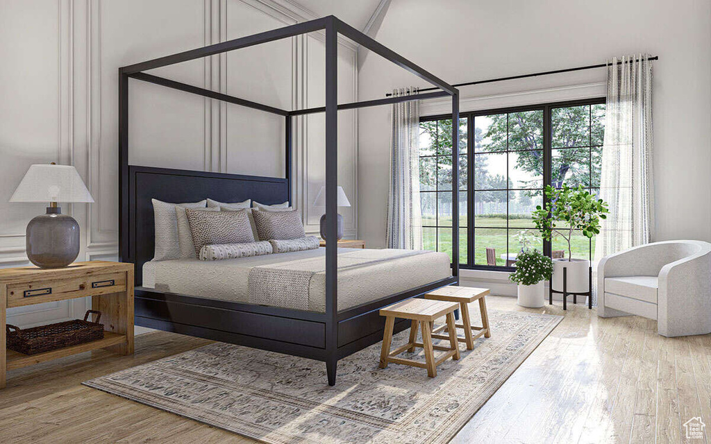 Bedroom with multiple windows and wood finished floors
