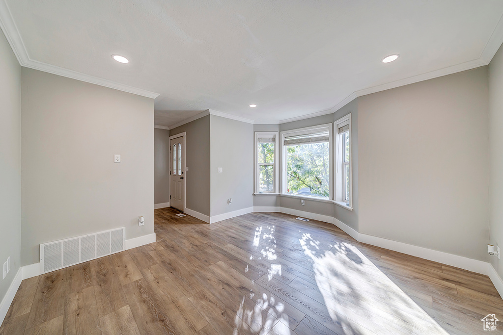 Empty room with baseboards, wood finished floors, recessed lighting, and ornamental molding