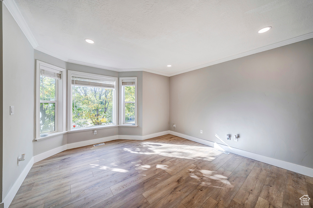 Unfurnished room with baseboards, ornamental molding, wood finished floors, and recessed lighting