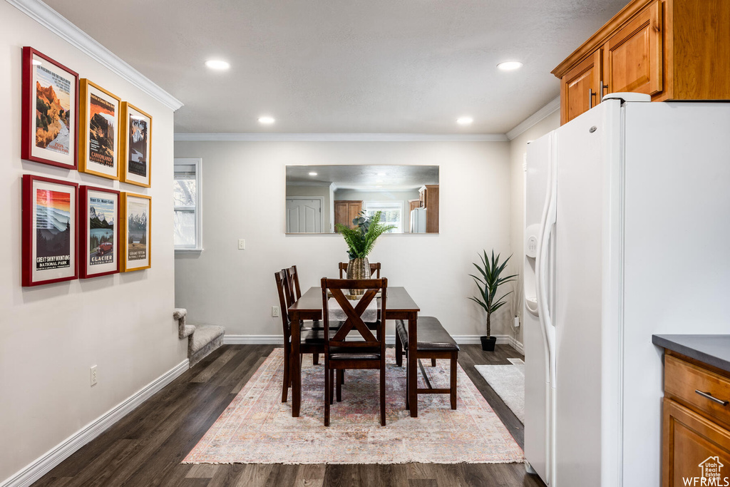 Dining space with dark wood finished floors, recessed lighting, and ornamental molding