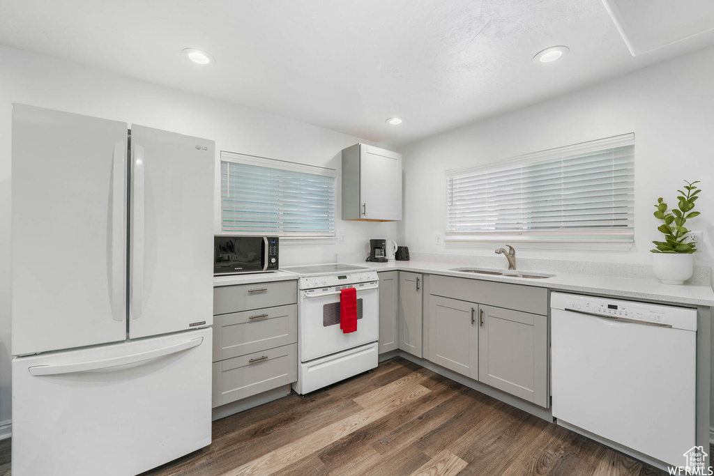 Kitchen with white appliances, gray cabinetry, dark wood finished floors, light countertops, and recessed lighting