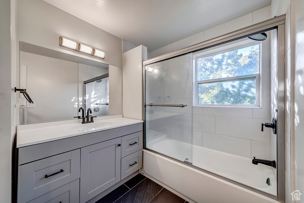 Full bath featuring vanity and combined bath / shower with glass door