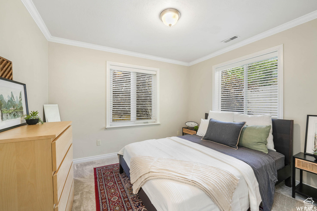 Bedroom featuring crown molding and light colored carpet