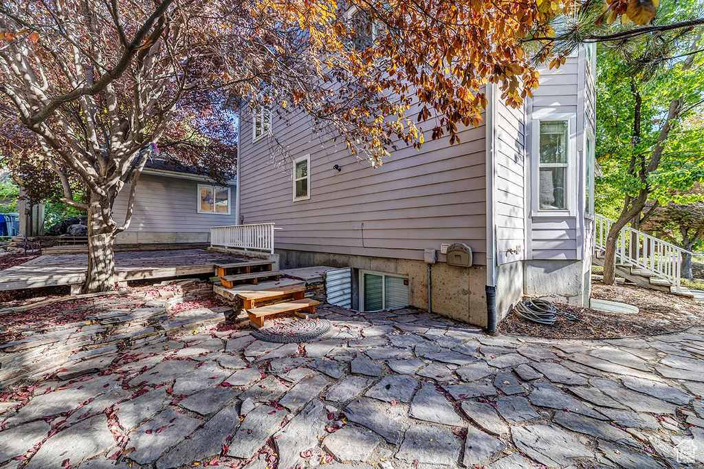 Back of property featuring a wooden deck and a patio area