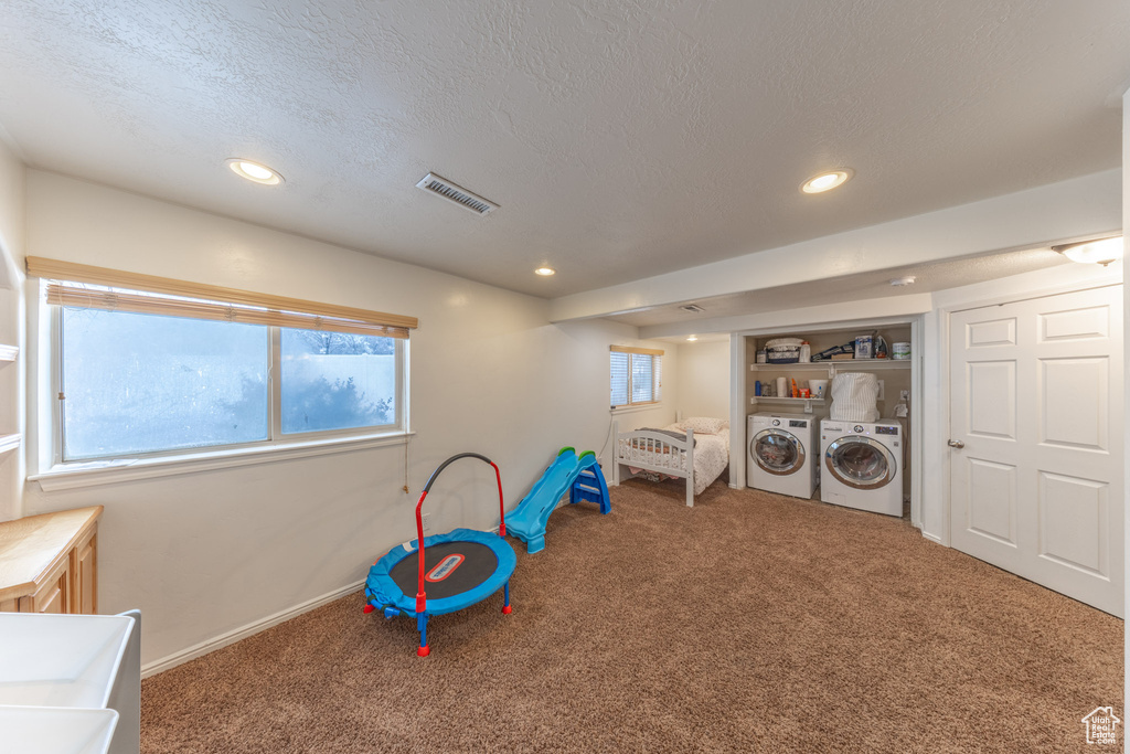 Game room featuring carpet floors, washer and dryer, a textured ceiling, recessed lighting, and baseboards