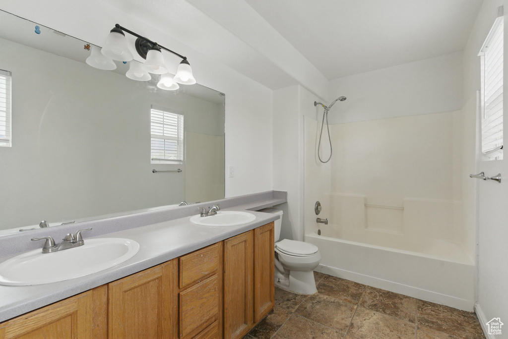 Bathroom with toilet, bathing tub / shower combination, and double vanity
