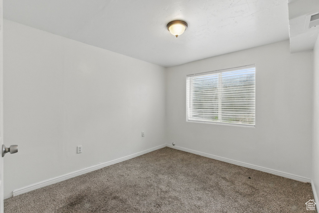 Carpeted spare room with baseboards