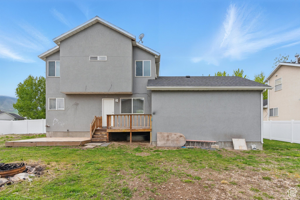 Back of house with a wooden deck and stucco siding