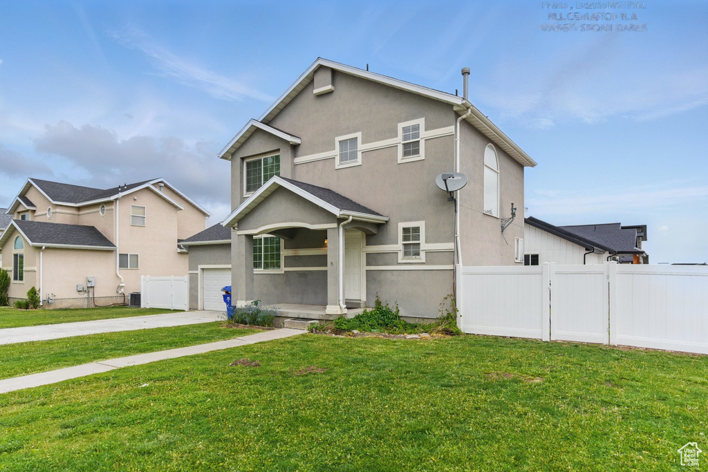 Traditional-style home featuring driveway, stucco siding, and an attached garage
