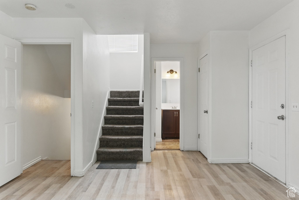 Staircase with wood finished floors and baseboards