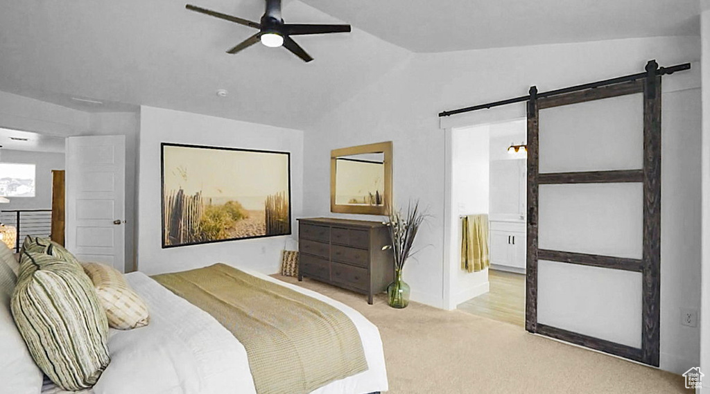 Bedroom featuring lofted ceiling, a barn door, carpet, a ceiling fan, and connected bathroom