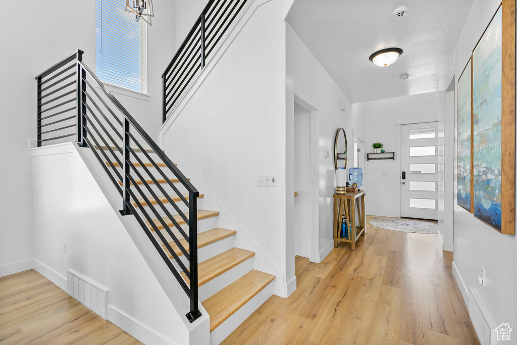 Entrance foyer featuring stairway, healthy amount of natural light, wood finished floors, and baseboards