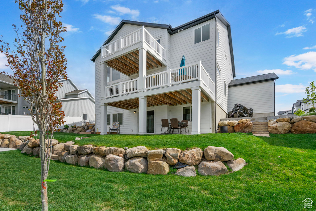 Back of house with a balcony and a patio