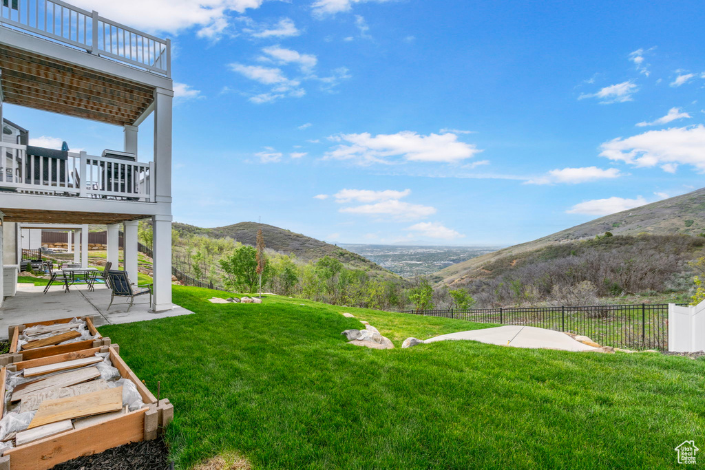 View of yard with a mountain view, a patio area, and a balcony