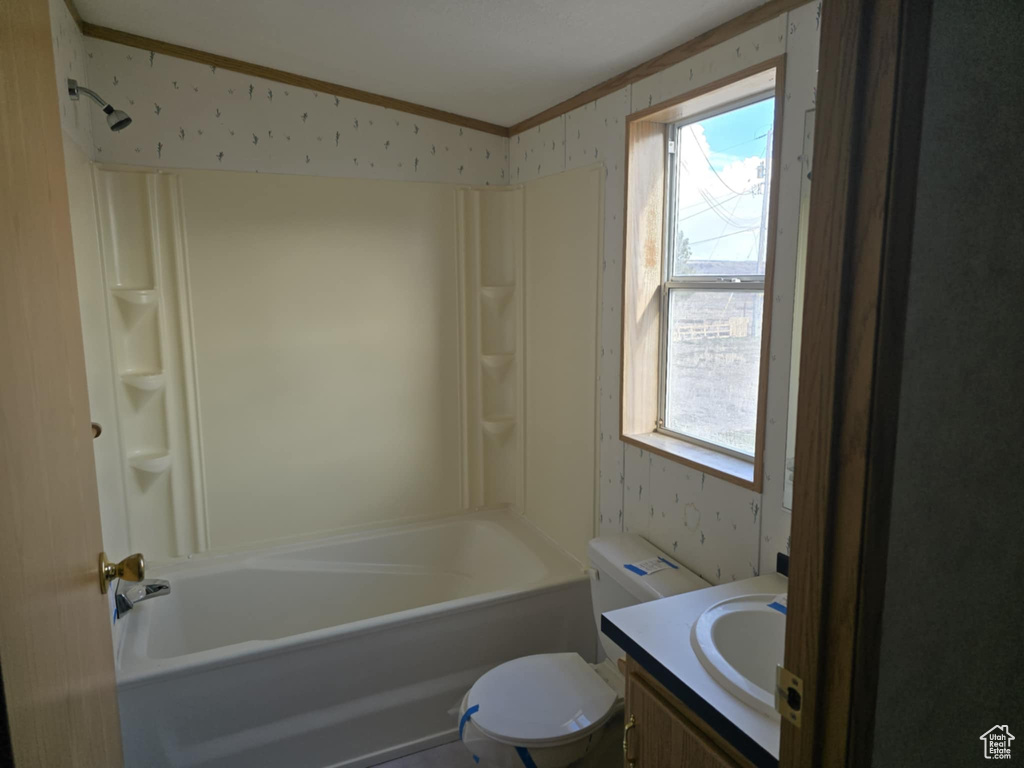Bathroom with crown molding, wallpapered walls, plenty of natural light, vanity, and lofted ceiling