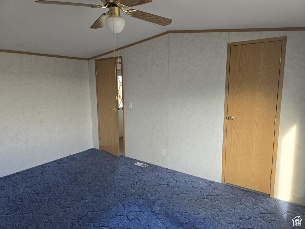 Unfurnished bedroom with crown molding, vaulted ceiling, carpet flooring, and a ceiling fan