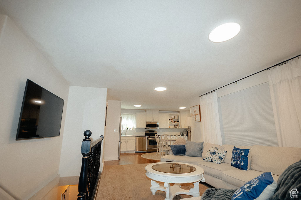 Living room with recessed lighting, baseboards, and light wood-type flooring