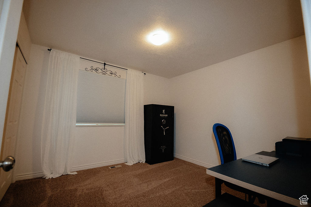Carpeted home office featuring baseboards