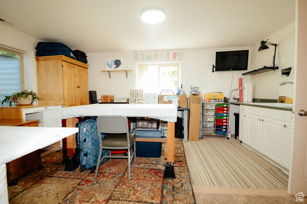 Kitchen featuring open shelves, a sink, white cabinetry, and light colored carpet