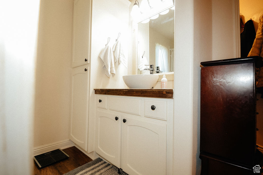 Bathroom featuring vanity, wood finished floors, and baseboards