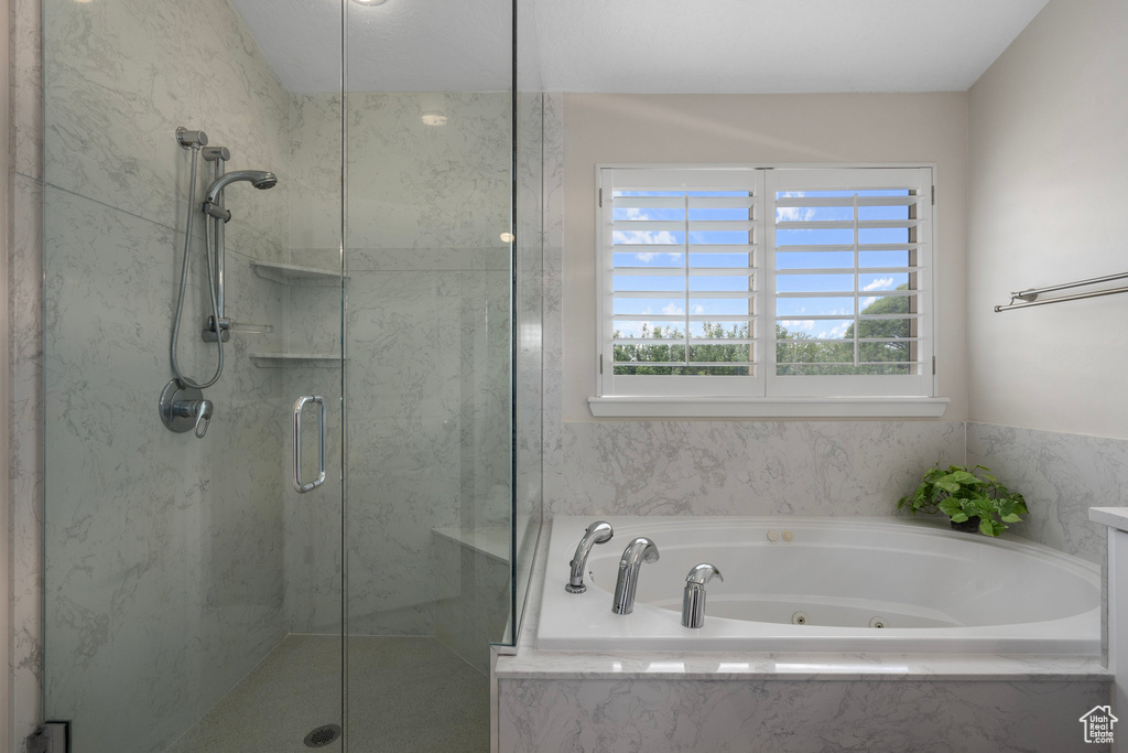 Full bath featuring a marble finish shower and a tub with jets