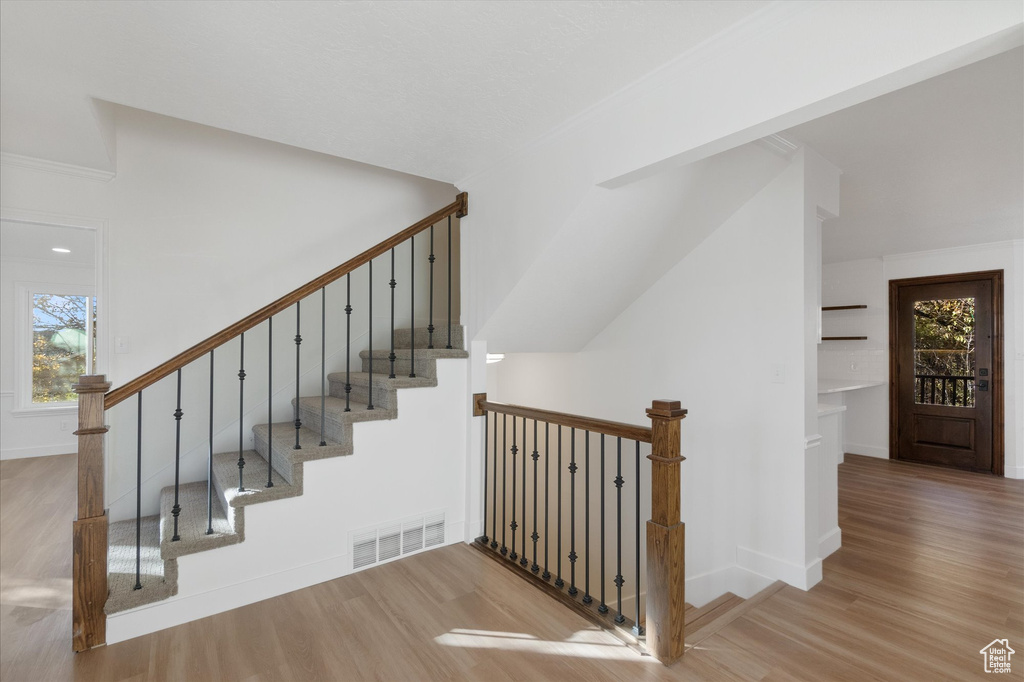 Stairs featuring baseboards, visible vents, and wood finished floors
