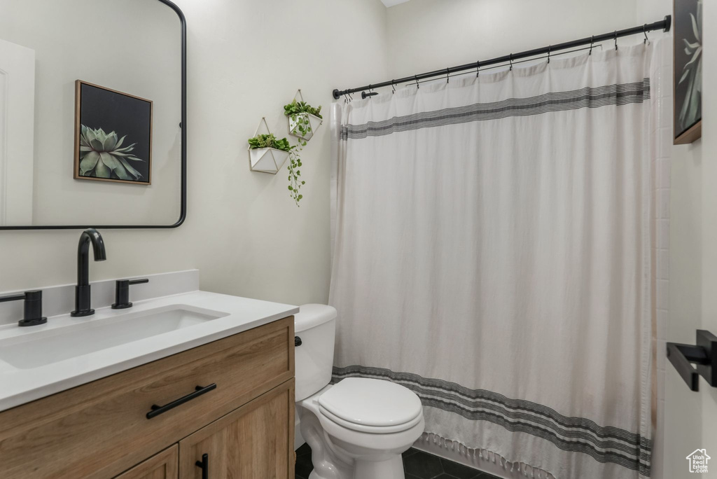 Full bath featuring toilet, vanity, tile patterned floors, and a shower with shower curtain