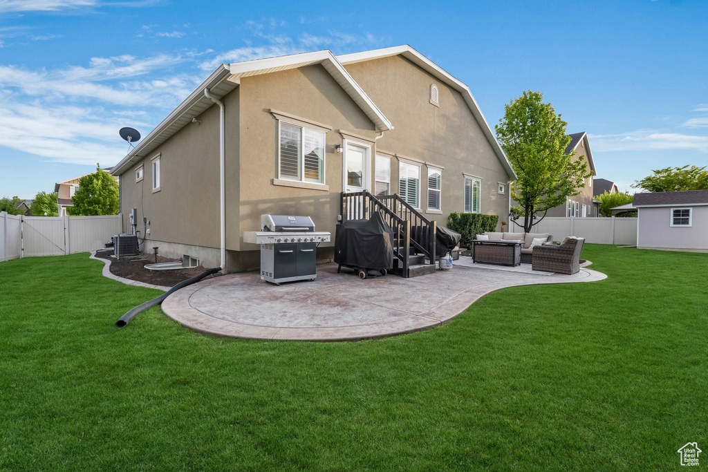 Back of house with an outdoor hangout area, a patio, stucco siding, central AC unit, and a gate